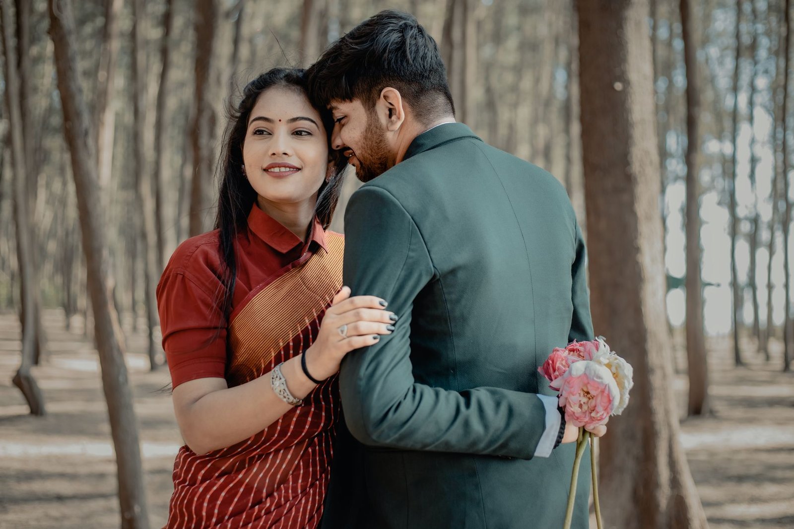 A loving couple dressed for a wedding poses in a serene forest setting, highlighting romance and nature.