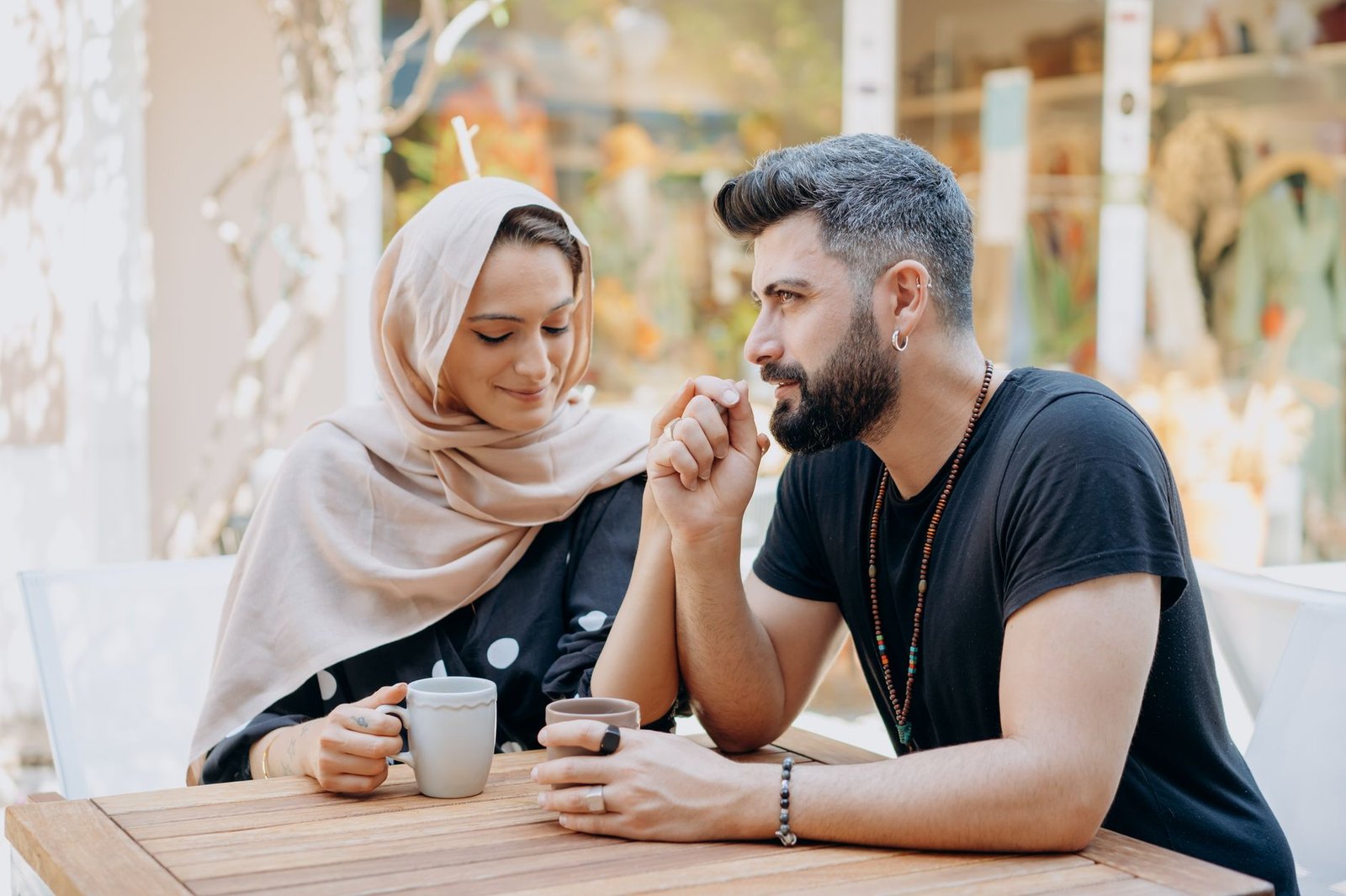 A loving couple holding hands and enjoying a summer coffee date outdoors.
